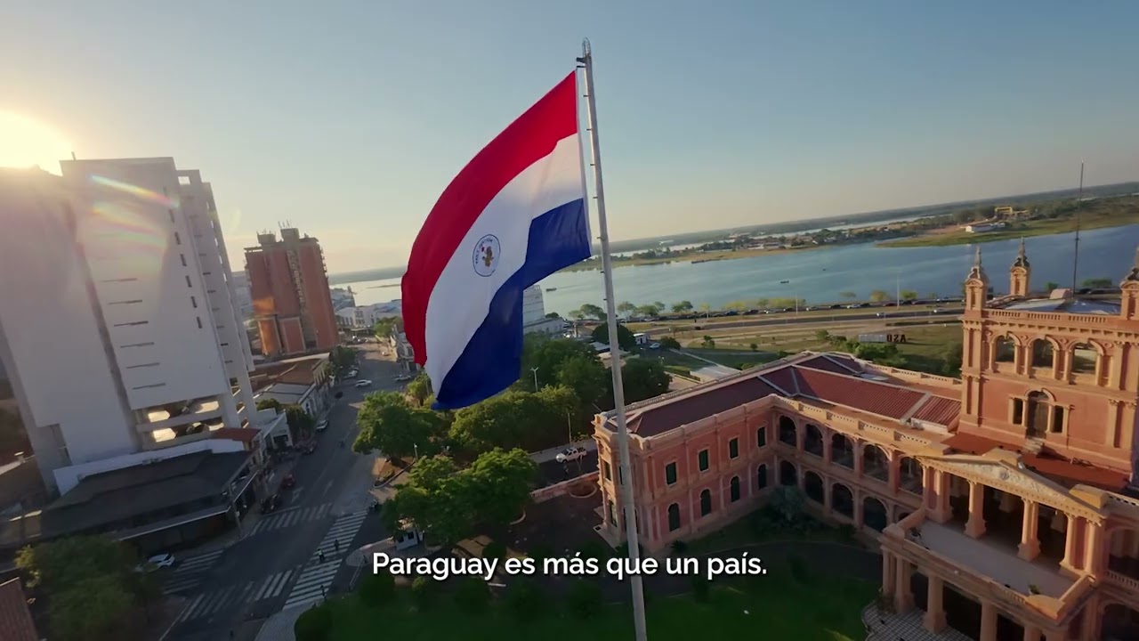 Bandera del Paraguay frente al Palacio de López y la bahía de Asunción